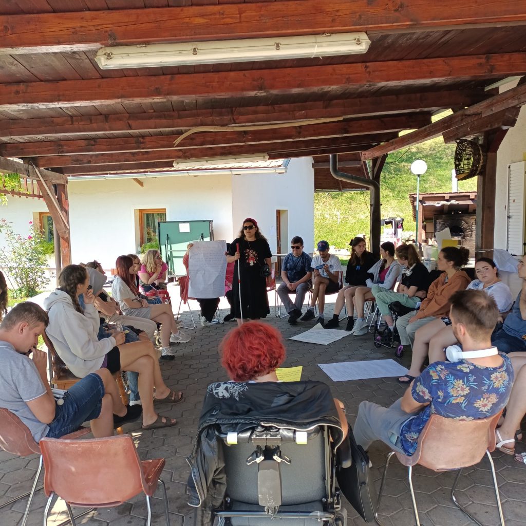 Yarı açık alanda u düzeninde oturmakta olan katılımcıların yer aldığı bir kare