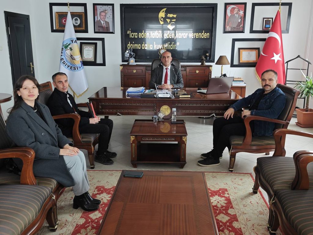 görselde 4 kişi var. biri görme engelli bir birey 3 erkek 1 kadın var. otuuryorlar.